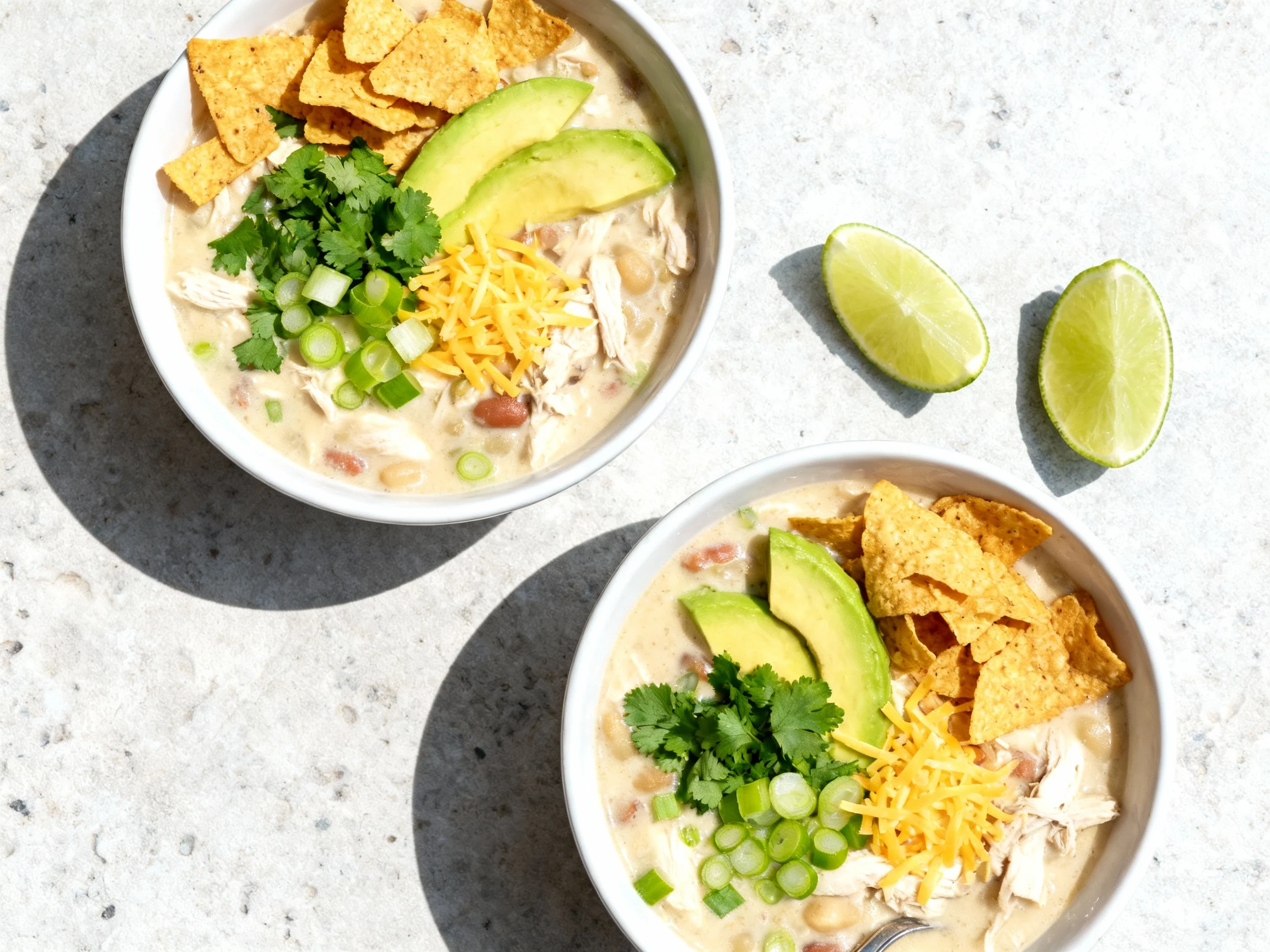 Food photography, 2. Overhead shot of two bowls of creamy crockpot white chicken chili, topped with chopped cilantro, av