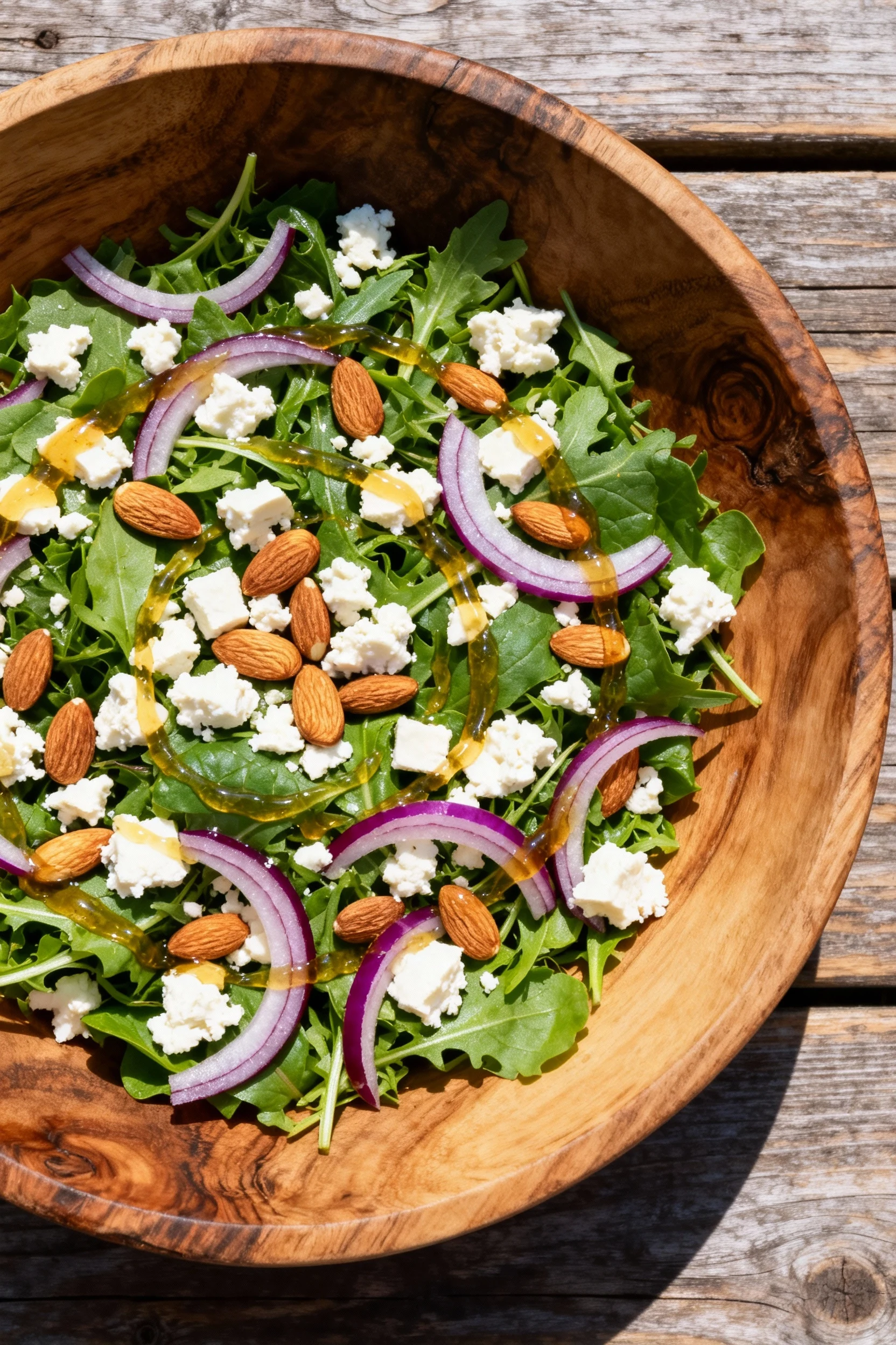 Overhead shot of the fully assembled summer salad in a wide rustic wooden bowl, showing the colorful arrangement of gree