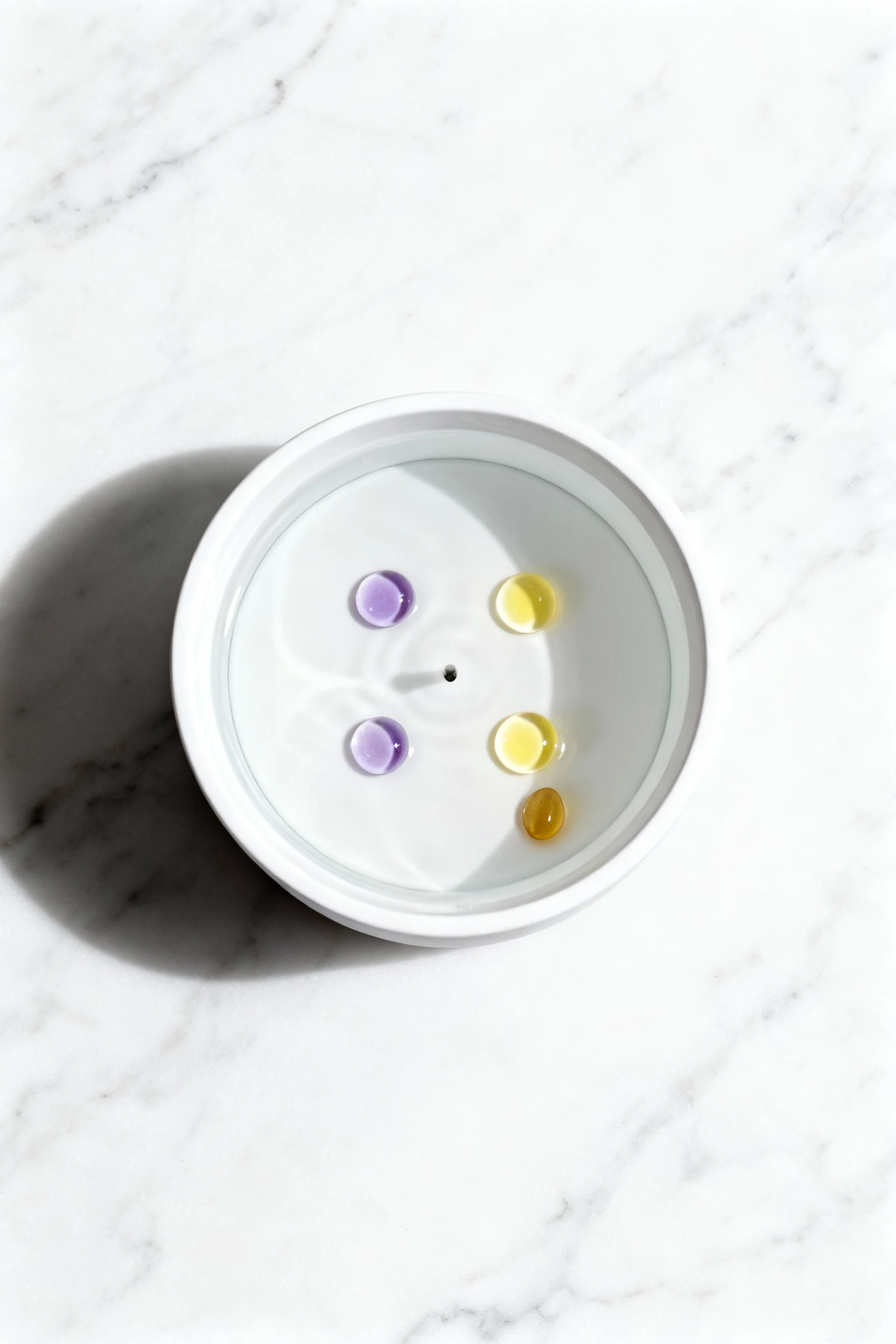 Overhead shot of diffuser reservoir before run: water filled with 5 counted drops (2 lavender, 2 lemon, 1 frankincense) 