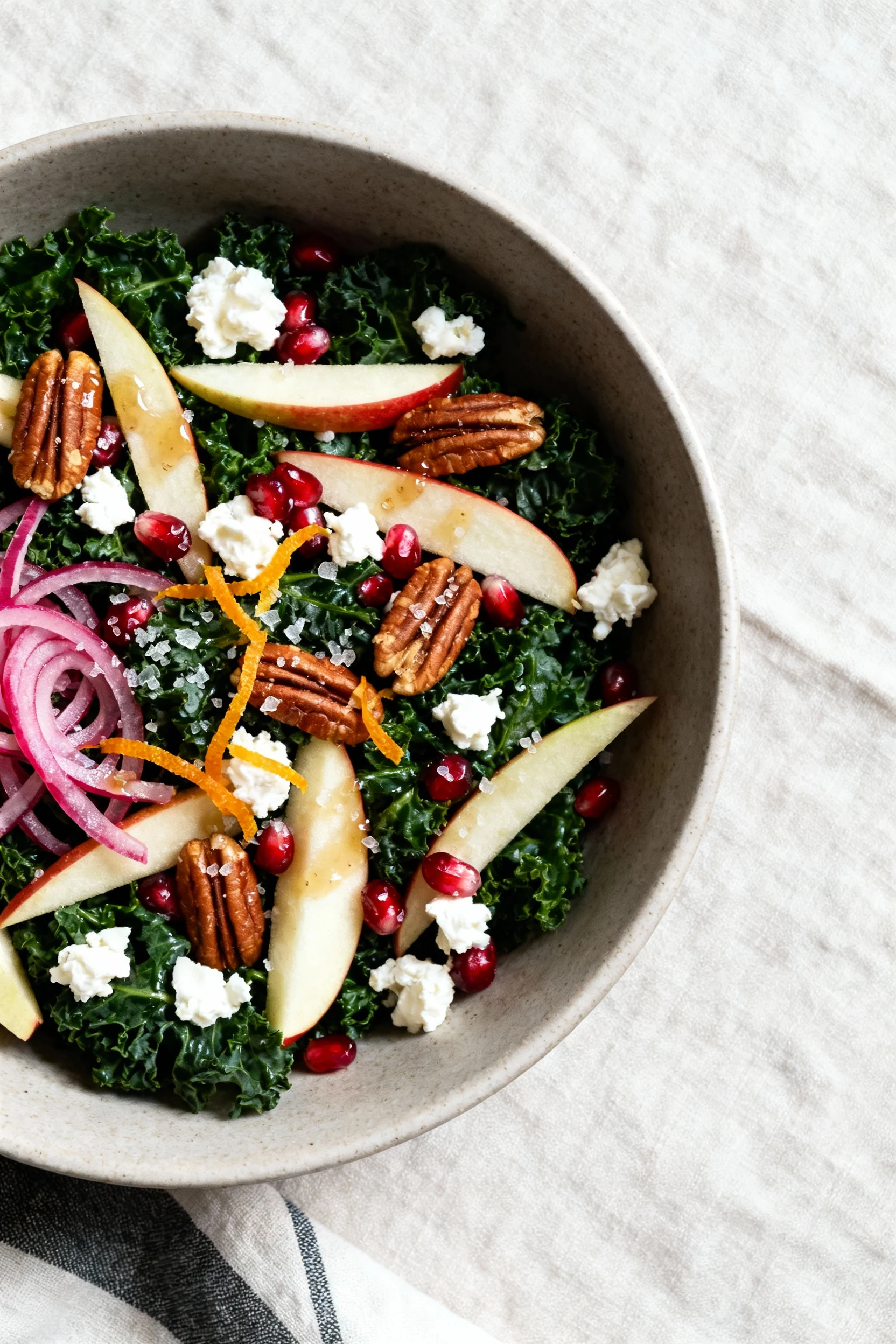 Overhead shot of the assembled winter kale salad: massaged lacinato kale, Honeycrisp apple matchsticks, ruby pomegranate