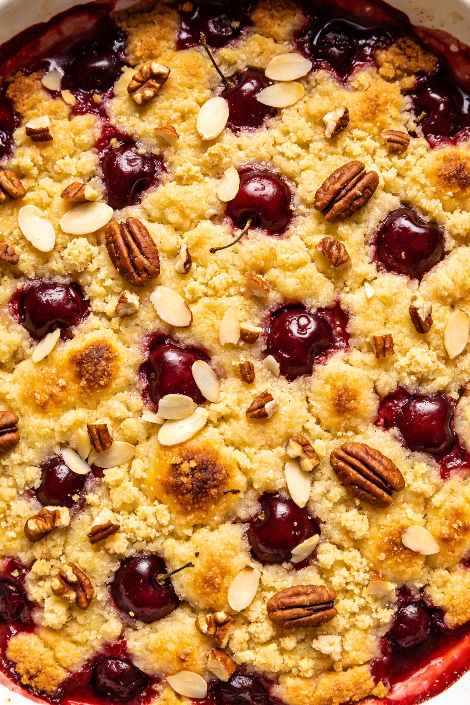 Overhead shot of the finished cherry dump cake showing an even blanket of baked yellow cake topping with scattered slice