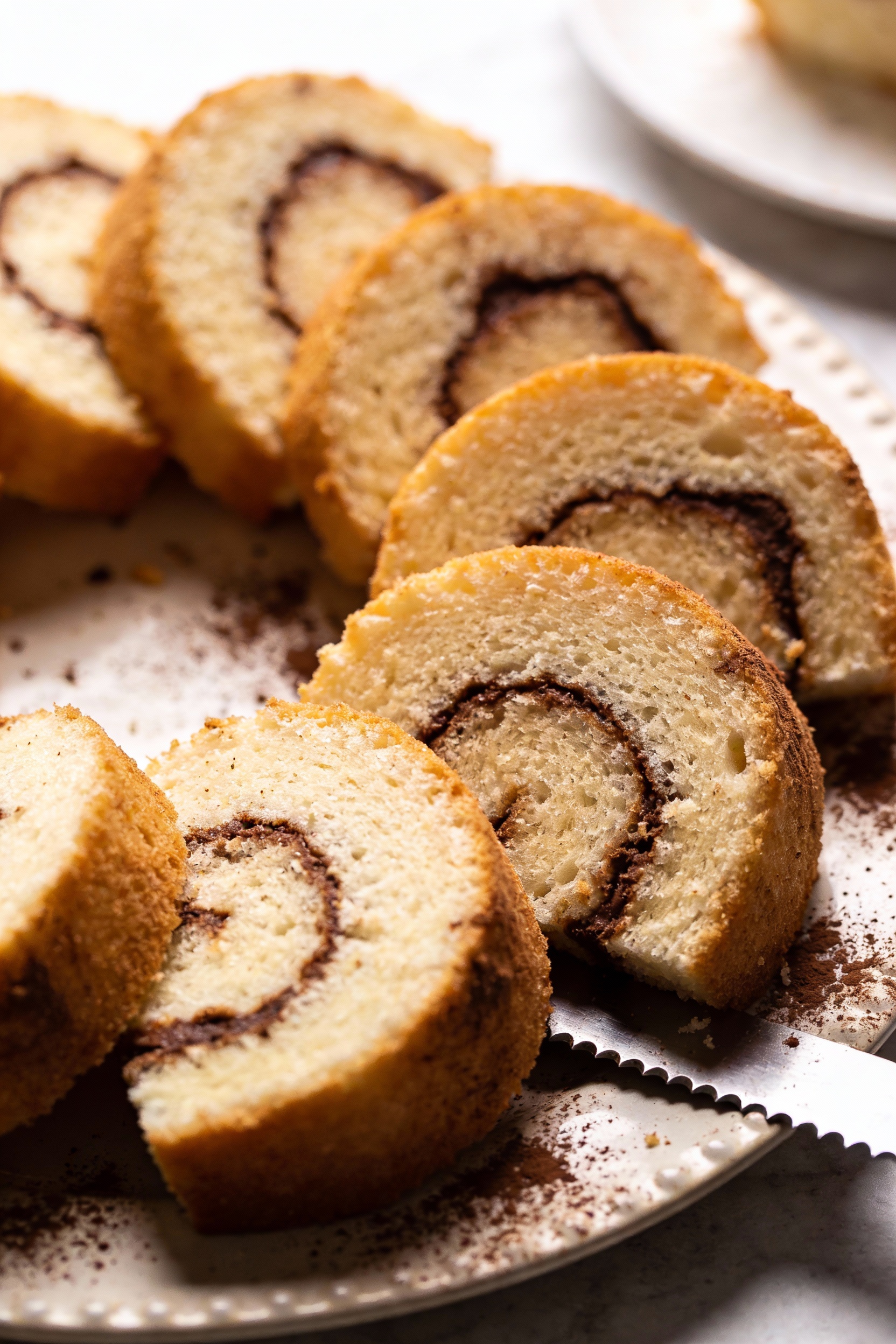 \Top-down view of angel food cake slices arranged in a ring on a platter showing a light chocolate swirl marbled through