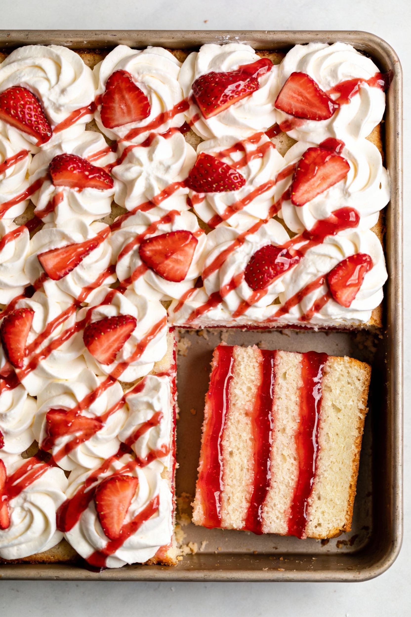 Final dish presentation: Strawberry poke cake in a 9x13 pan—whipped topping swirled to soft peaks, fresh strawberry slic